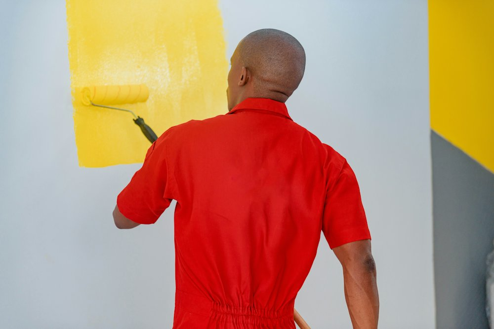 Painter rolling paint onto a wall